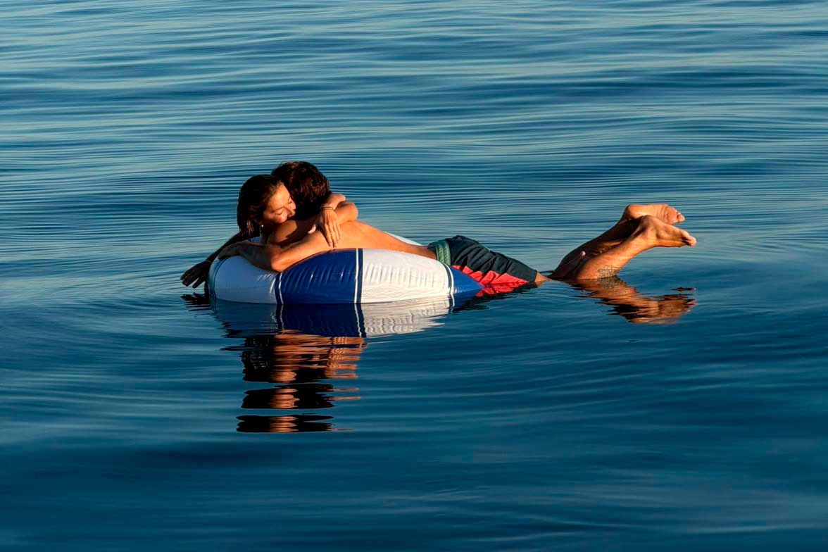 Couple relaxing on floating donuts during a private sailing trip in Marbella